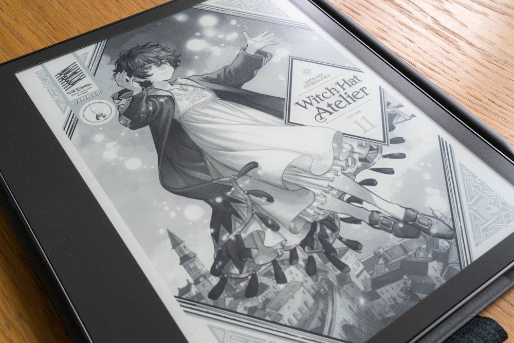 A manga volume cover displayed in fine grey tones on a large e-ink reader.